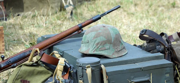 Helm der Soldatenuniform mit Gewehr im Armeelager — Stockfoto