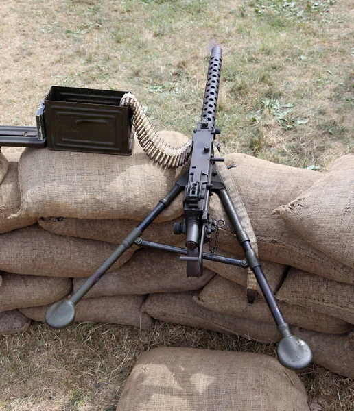Metralhadora com balas sobre os sacos de areia na guerra de trincheiras — Fotografia de Stock