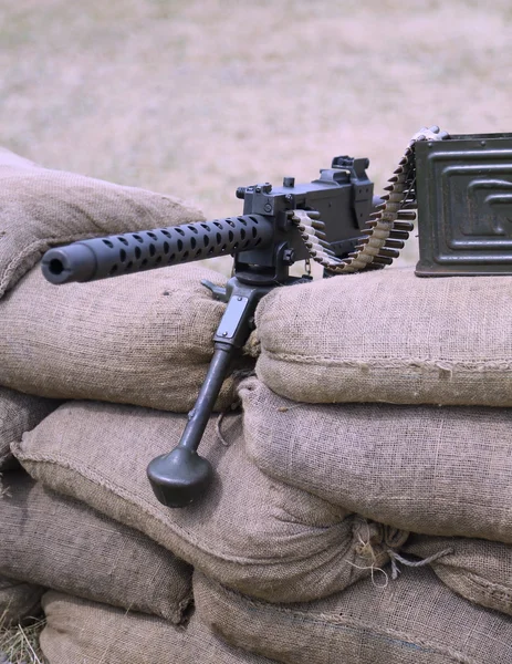 Ametralladora histórica con balas sobre los sacos de arena en trinchera — Foto de Stock