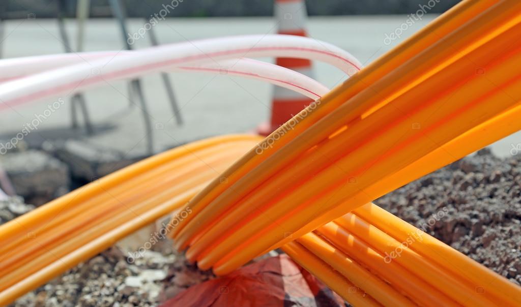 Orange pipes for fiber optics in a large city road construction — Stock