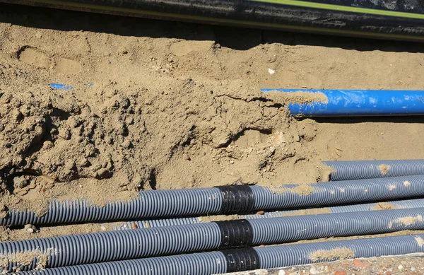 Tubos corrugados para la colocación de cables eléctricos en la excavación Imagen De Stock