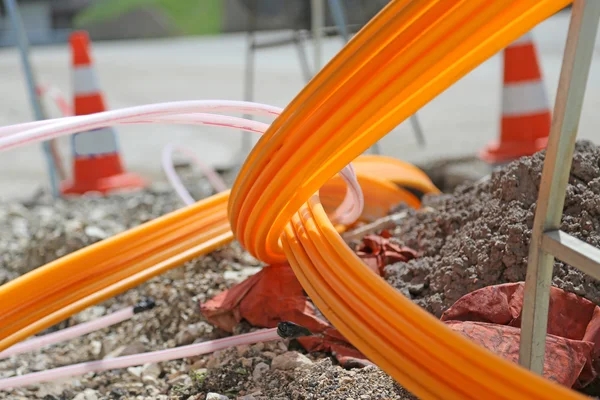 Tubos naranjas para fibra óptica en una gran construcción de carreteras urbanas — Foto de Stock