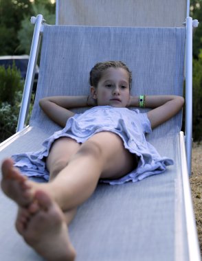 sevimli küçük kız güverte üzerinde günbatımında dinlenme