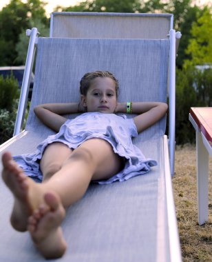 güzel yalınayak kız güvertede gün batımında aittir.