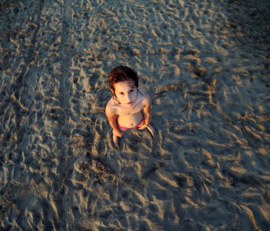 Kum ortasında mayo ile yalnız genç kız