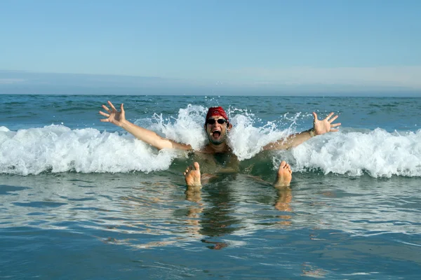 Homme au chapeau rouge dans les vagues de la mer — Photo