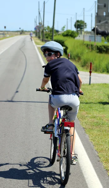 Enfant de dix ans va à vélo avec casque — Photo