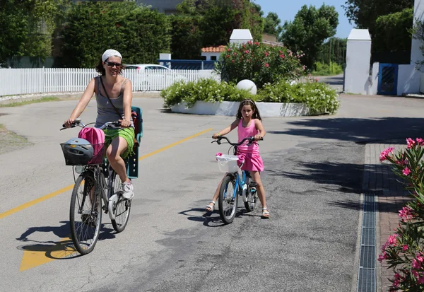 Мама со своей маленькой девочкой катаются на велосипеде летом — стоковое фото