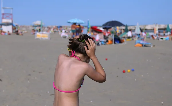 Little girl plays with the bowls on the beach — Stock Photo, Image