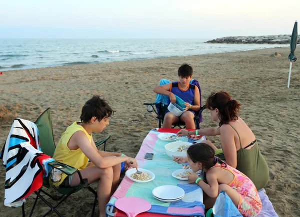 Very Happy family eats rice on the Beach in summer — Stock Photo, Image
