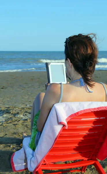 Femme lit l'ebook sur la plage — Photo