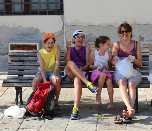 Família feliz rindo no banco fazendo piqueniques — Fotografia de Stock