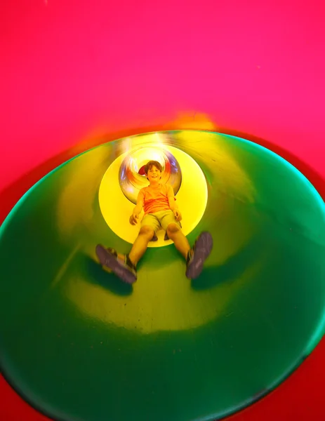 Child on the playground comes down to one big tunnel slide — Stock Photo, Image