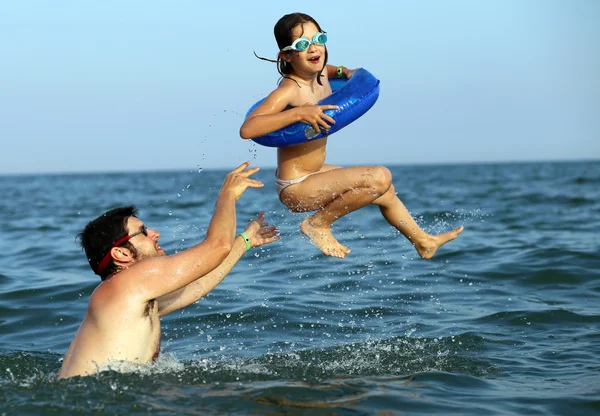 Papà gioca con sua figlia facendola fare alte immersioni in mare — Foto Stock