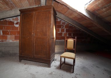 ahşap dolap ve tozlu tavan arasındaki bir antika sandalye