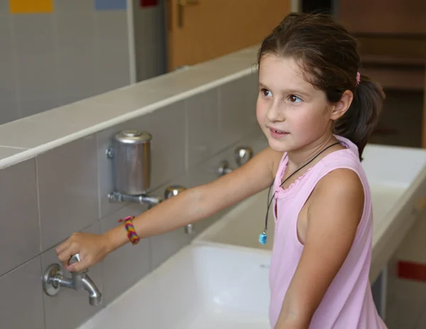 Little girl is washing her hands in the bathroom of the school — Stock Photo, Image