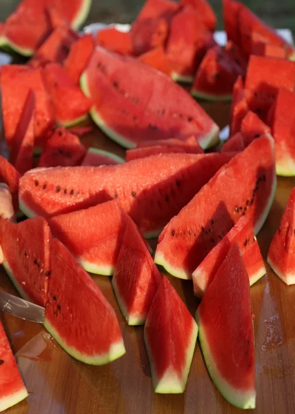 Skivor av mogen röd vattenmelon på utomhusrestaurangen bord — Stockfoto