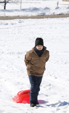 Şapka ve bob kar üzerinde genç çocuk
