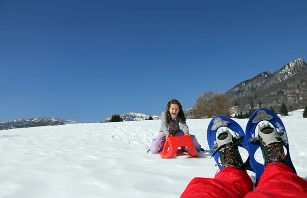 Playing with red sled on the snow in the mountains — Stock Photo, Image