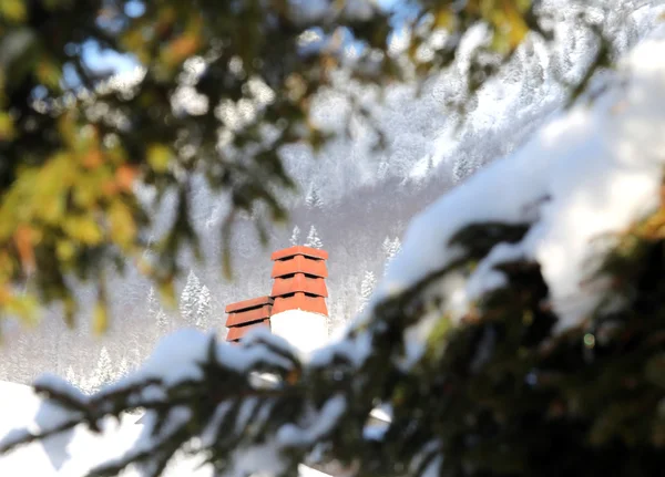 Chimeneas de una casa en las montañas con nieve —  Fotos de Stock