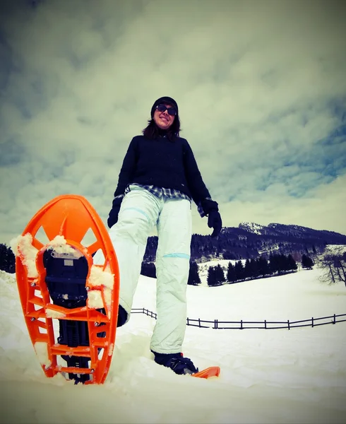 Bela jovem com sapatos de neve na neve — Fotografia de Stock