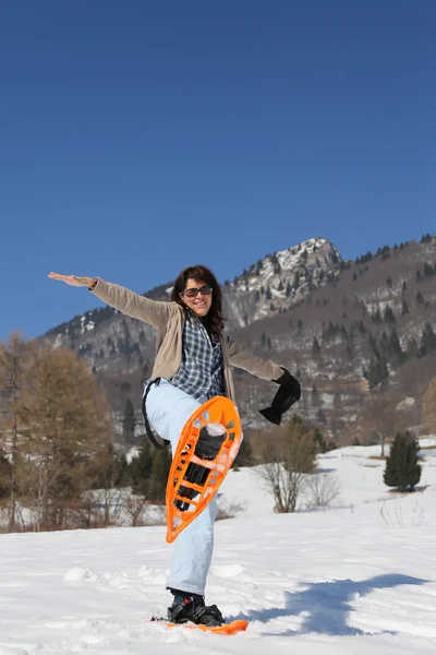 Mulher com sapatos de neve na neve branca — Fotografia de Stock