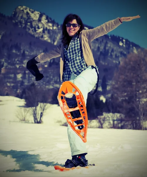 Beautiful woman with snowshoes in the snow — Stock Photo, Image