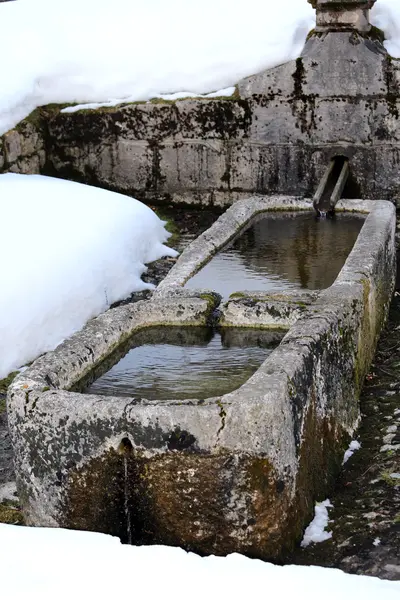 Fuente de piedra con agua fría helada en invierno —  Fotos de Stock