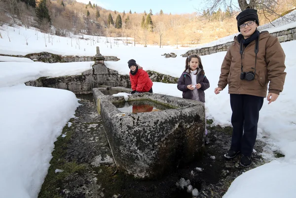 Troje dzieci w pobliżu monumentalna fontanna z zimną wodą — Zdjęcie stockowe