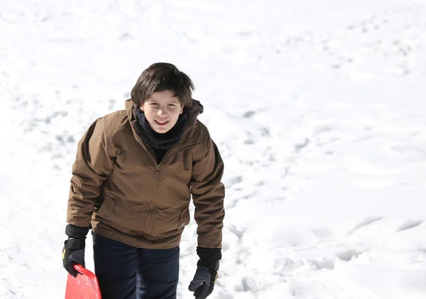 Boy plays with sledging in winter on the white snow — Stock Photo, Image