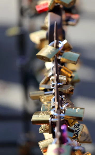 De nombreux grands cadenas suspendus sur le côté du pont — Photo