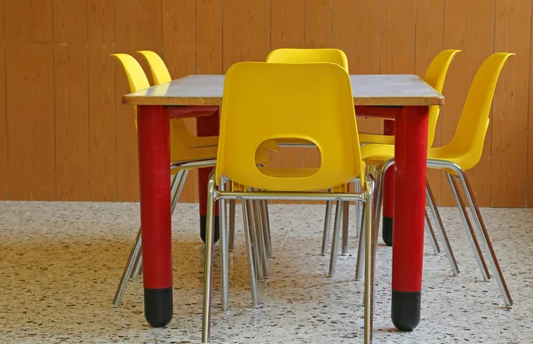 Kindergarten classroom with desks and yellow chairs — Stock Photo, Image