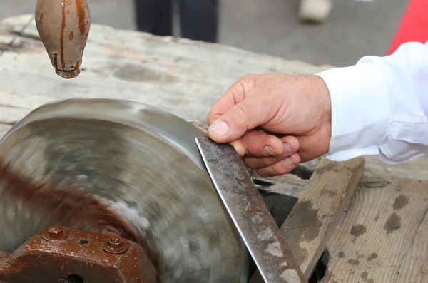 Knife sharpener while sharpening the blade of the knife — Stock Photo, Image