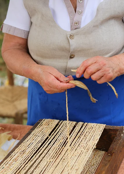 Anciana mujer crea bolsos de paja — Foto de Stock