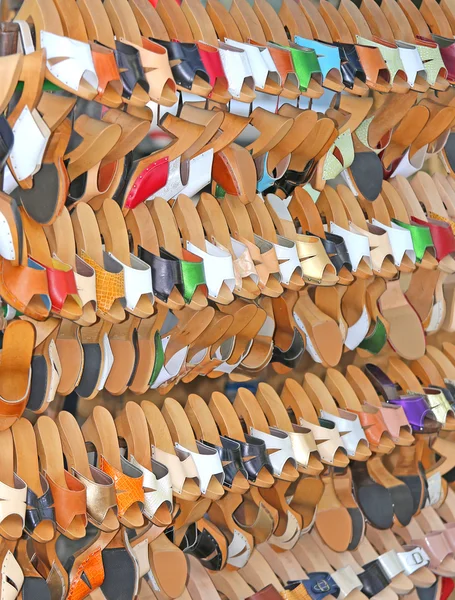 Магазин с большим количеством деревянной обуви и цветной кожи — стоковое фото