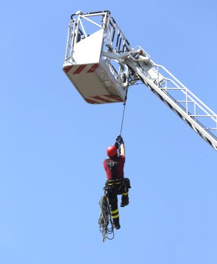 binanın içinde iple aşağı itfaiyeci