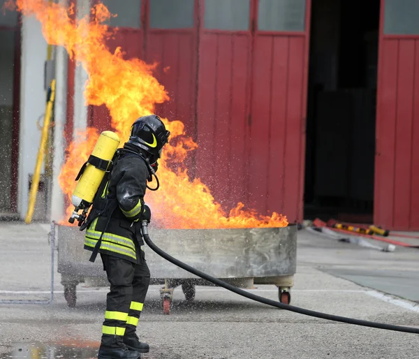 Пожарные с бутылками кислорода от огня во время тренировки — стоковое фото