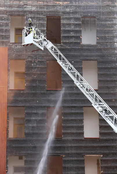 Vigili del fuoco nel cesto camion dei pompieri durante la pratica del tra — Foto Stock