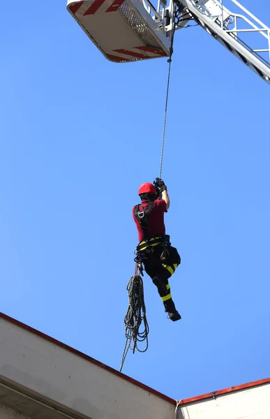 Bombero abajo con la cuerda en el edificio durante una alarma de incendios — Foto de Stock