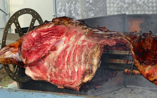 Beef cooked on a spit with the embers in the outdoor restaurant — Stock Photo, Image