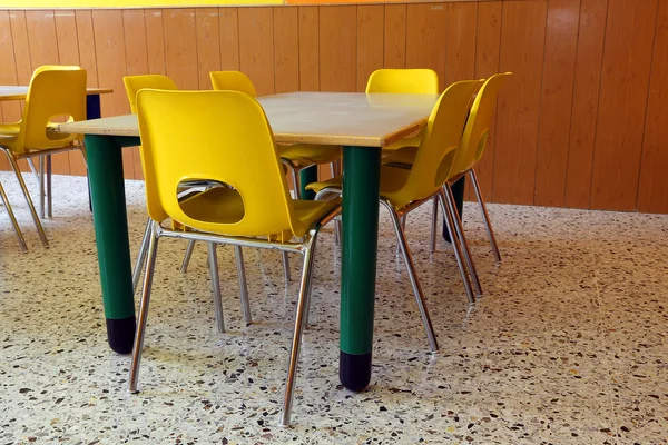Przedszkole z biurka i krzesła żółty bez dzieci — Zdjęcie stockowe