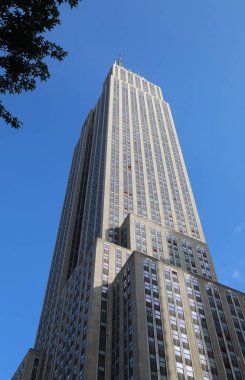 New York, New York, ABD - 24 Ağustos 2025: Empire State Binası aşağıdan ve Manhattan 'ı çevreleyen mavi gökyüzü