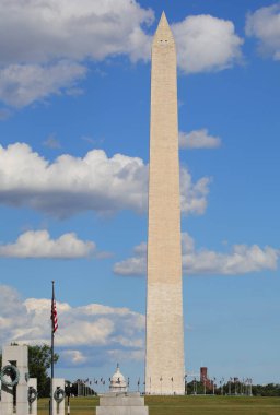 Washington, DC, ABD - 26 Ağustos 2025: Washington Anıtı 'ndan uzun boylu beyaz bulutlu mavi bir gökyüzüne karşı dimdik duran ve ABD Kongre Binası' nı bayraklarla görülebilen