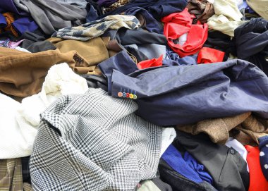 İkinci el pazarında bol bol kullanılmış giysiler satan bir tezgah.