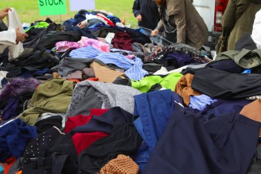 İkinci el mağazası, açık bit pazarında birikmiş kaliteli kontörlü giysilerle dolu.