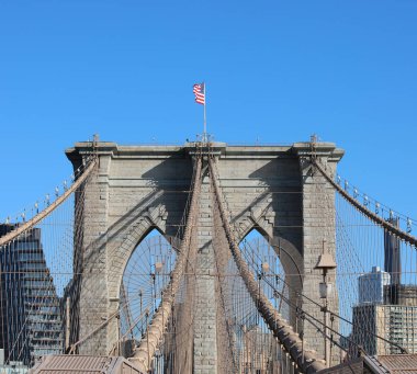 New York 'un sembollerinden biri Brooklyn Köprüsü kulesi ve sallanan Amerikan bayrağı.