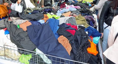 Bir bit pazarında sayısız kullanılmış giysi ve giysi yığını.