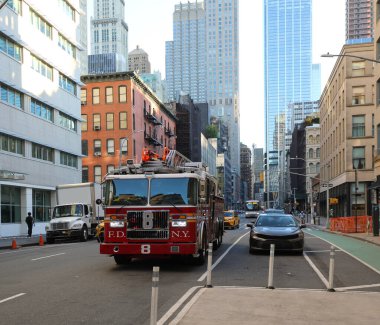 New York, New York, ABD - 23 Ağustos 2025: New York itfaiye aracı Manhattan sokaklarında ve arka plandaki gökdelenlerde hızla ilerliyor