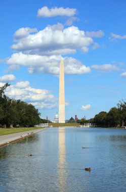 Washington, DC, ABD - 26 Ağustos 2025: Washington Anıtı Obelisk Mall havuzu ve Capitol Hill kubbesine yansıyor
