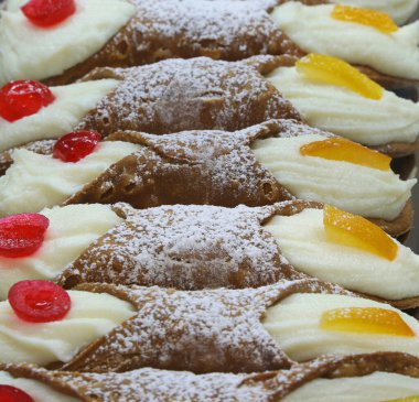 İtalyan pastanesinde satılık meyve ve kirazlı ricotta kreması ile dolu bir sürü Sicilyalı cannoli.